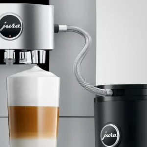 JURA coffee machine using a milk pipe with stainless steel casing to prepare a layered latte macchiato from a milk container.